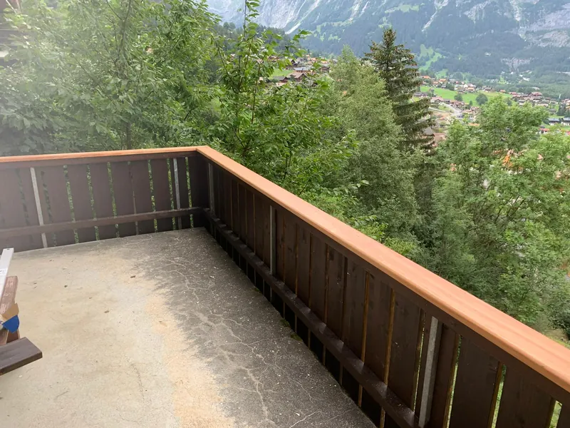 Erneuerte Balkonbrüstung aus Holz mit Blick ins Tal von Grindelwald