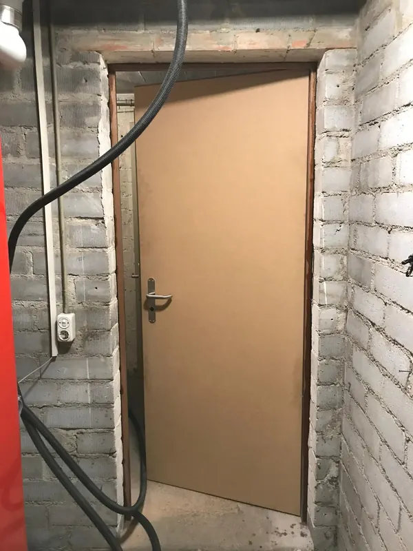 Neu eingebaute Brandschutztüre in einem Kellerraum mit Mauerwerk